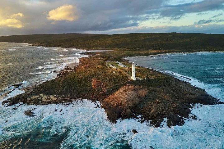 Aerial view of Cape Leeuwin Lighthouse situated on a rocky coastal peninsula.